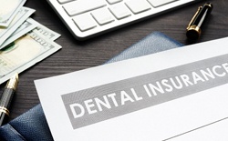 Dental insurance claim form and pen on a desk.