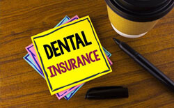 Dental insurance written on yellow notepad