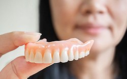 Close up of woman holding a full denture
