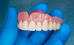 Close up of denture in gloved hand