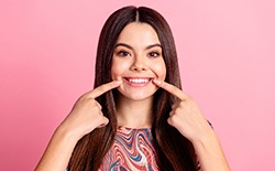 Woman pointing to her smile