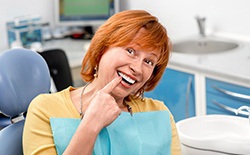 Woman pointing to her new dental implant in Texarkana