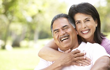 Couple with dentures in Texarkana smiling together outside