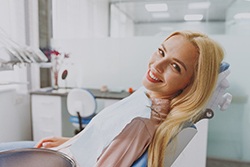 Blonde female patient leaning back in chair and smiling