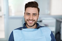 Male dental patient sitting down and smiling