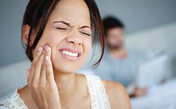 woman gritting teeth in pain