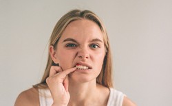 woman looking at her gums in the mirror