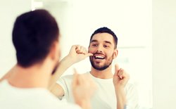 man flossing at home