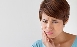 Woman holding jaw in pain