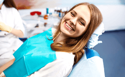 Female dental patient leaning back in chair and smiling