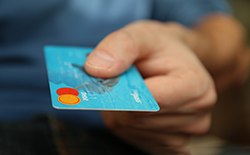  Man extending debit card for payment