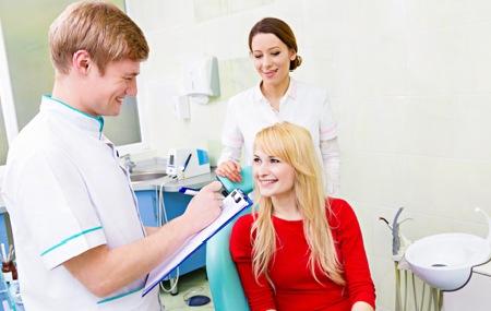 Woman in dental chair smiling at dentist