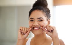 Woman flossing teeth