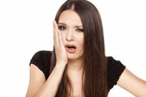 woman with toothache looking concerned