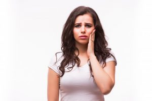 woman holding jaw in pain