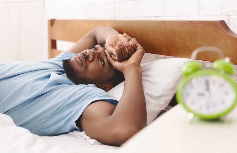 Worried man lying awake in his bed