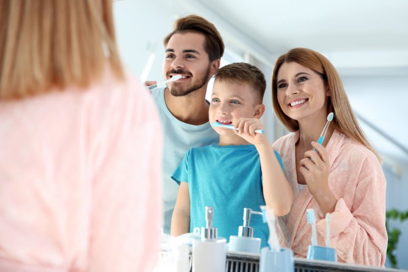 a family practicing brushing together for dental hygiene month